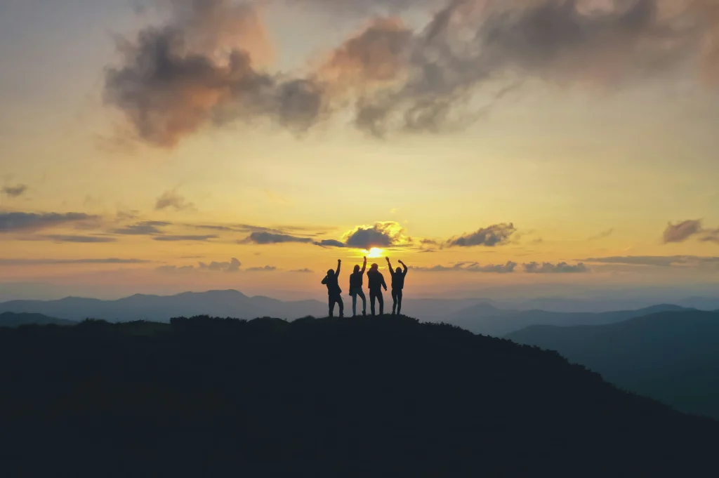 group of people on top of mountain during sunset